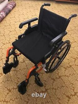 Black and orange frame Care Co wheelchair. Lightweight and foldable. Good design